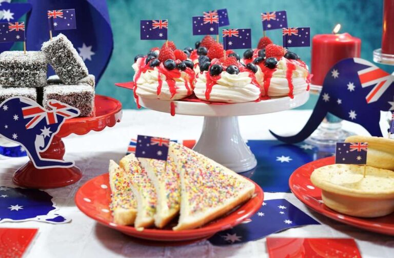 Australian food display with lamingtons, fairy bread, pavlovas and meat pies decorated with national flags.