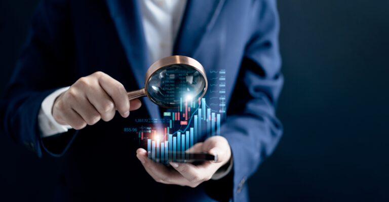 Businessman analysing charts on smartphone with magnifying glass, symbolising F&B acquisition and business value.
