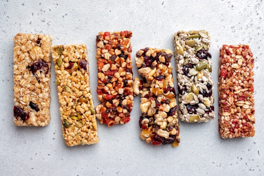 Assorted energy bars made from seeds, grains and dried fruit on a neutral background.