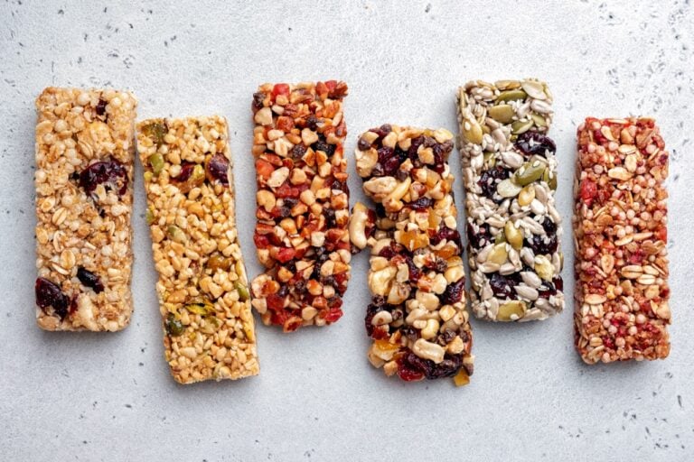 Assorted energy bars made from seeds, grains and dried fruit on a neutral background.
