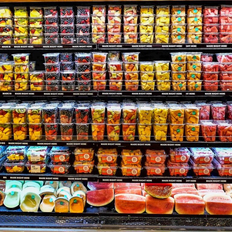 Packaged fresh fruit containers displayed on shelves inside a grocery retail store